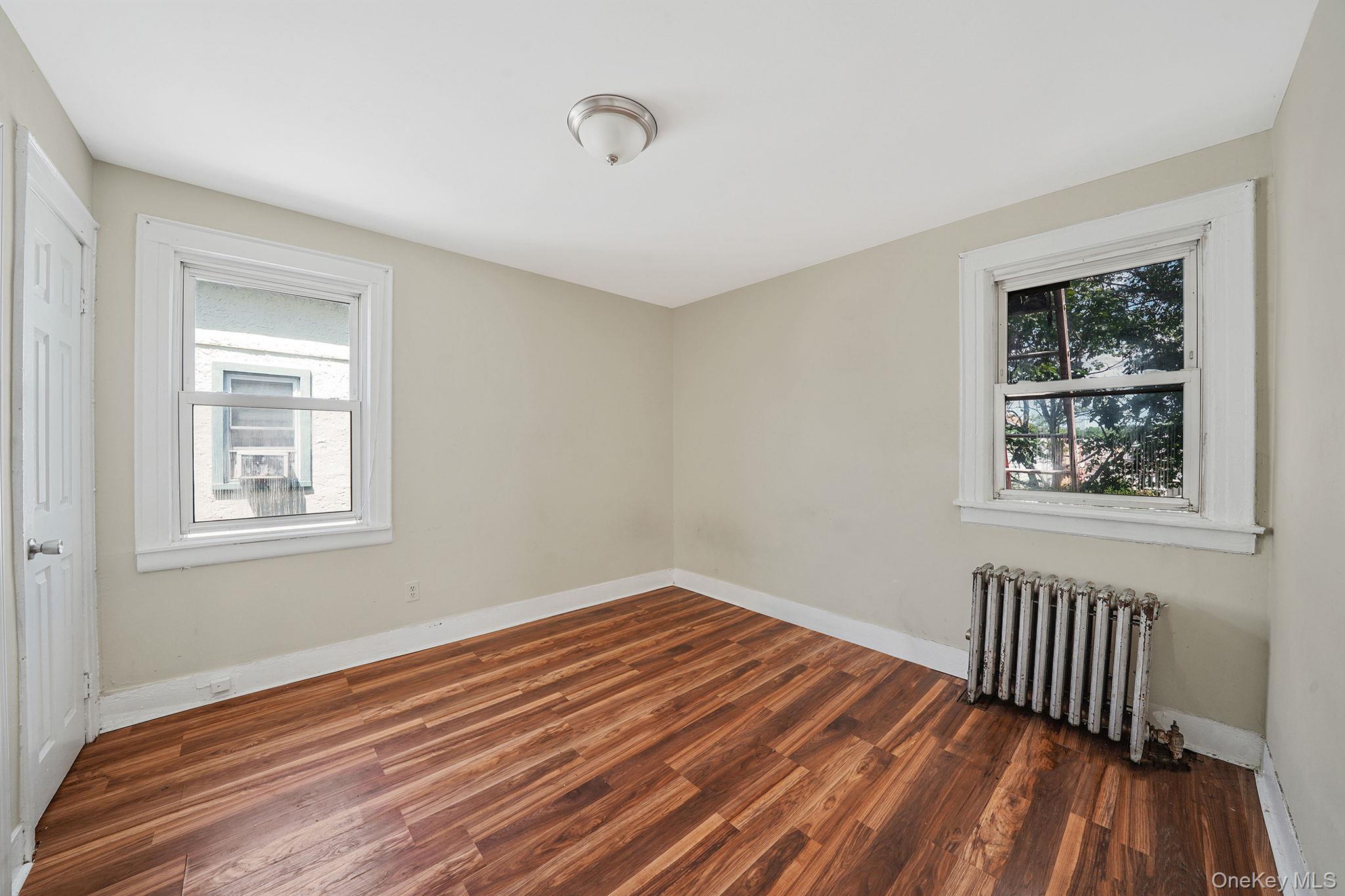 138-41 230th Place Queens, NY 11413 - Photo 10 of 17 a view of an empty room with wooden floor and a window