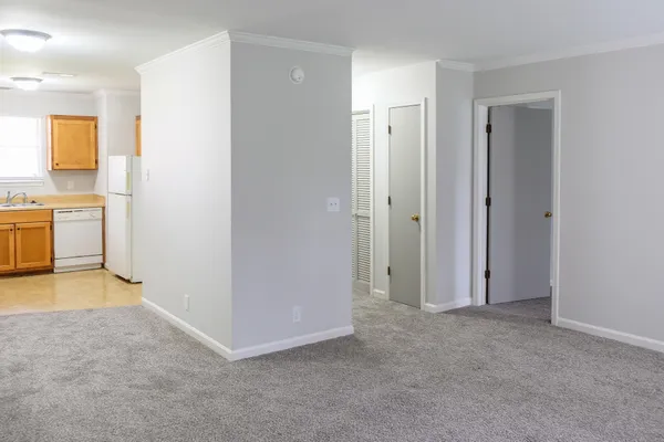 a view of a kitchen with a sink and dishwasher a refrigerator with white cabinets