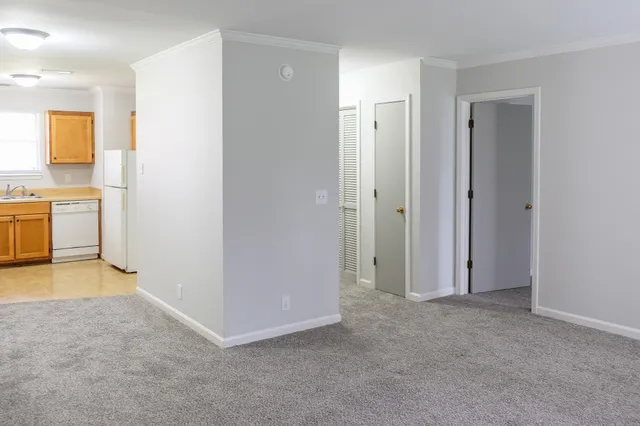 a view of a kitchen with a sink and dishwasher a refrigerator with white cabinets