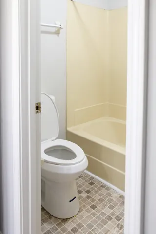 a bathroom with a toilet and a shower