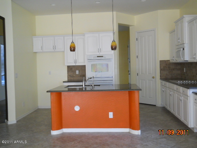 20864 West Ridge Road Buckeye, AZ 85396 - Photo 11 of 37 a kitchen with stainless steel appliances granite countertop a sink a stove and a refrigerator