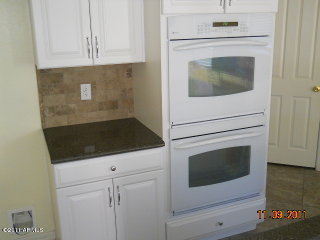 20864 West Ridge Road Buckeye, AZ 85396 - Photo 14 of 37 a kitchen with white cabinets and white appliances