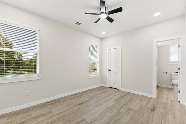 an empty room with wooden floor and windows
