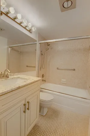 a bathroom with a granite countertop sink toilet and shower