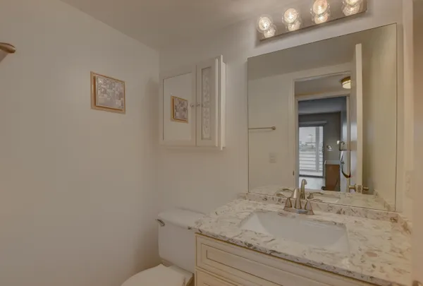a bathroom with a granite countertop sink and a mirror