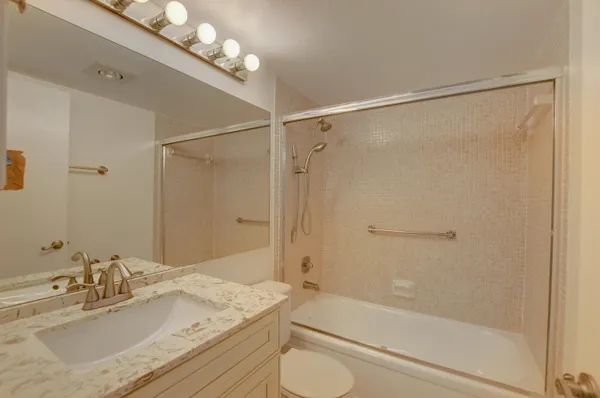 a bathroom with a granite countertop sink toilet and shower