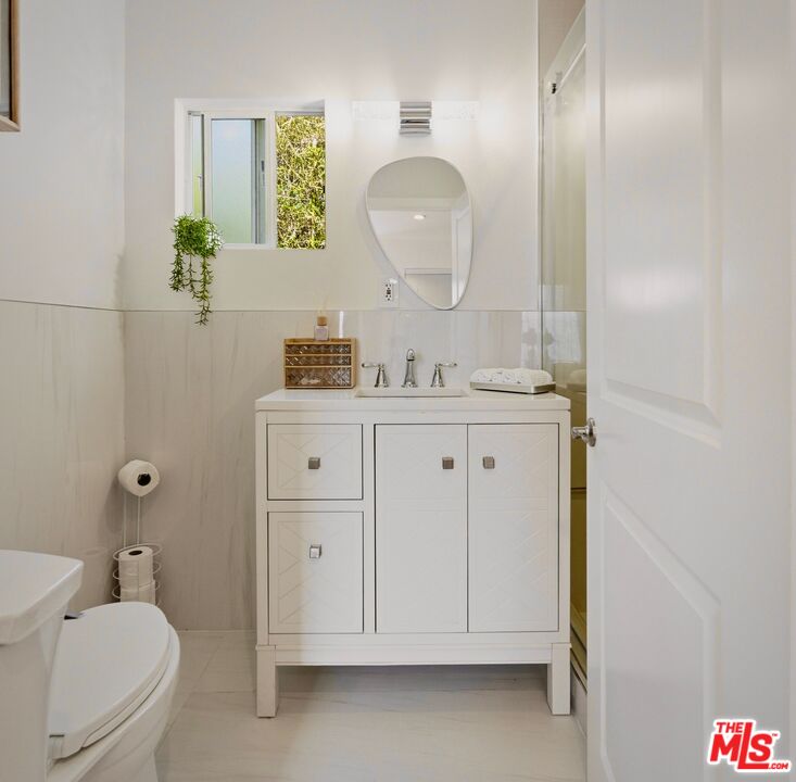 132 North Carson Road, Unit A Beverly Hills, CA 90211 - Photo 11 of 14 a bathroom with a sink a toilet and mirror