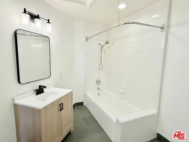 a bathroom with a bathtub a sink and a mirror