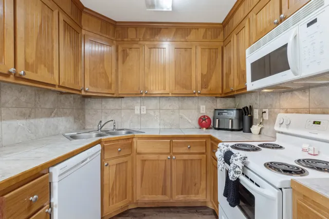 a kitchen with stainless steel appliances granite countertop a sink a stove and cabinets