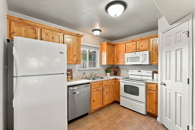 1041 South 1850th Street West Springville, UT 84663 - Photo 13 of 35 Kitchen featuring wood-finish cabinetry, light-toned countertops, and wood-finish flooring