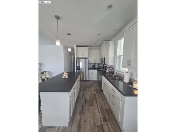 a kitchen with stainless steel appliances granite countertop a sink a stove and refrigerator