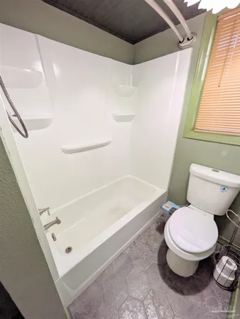 a white toilet sitting next to a bath tub
