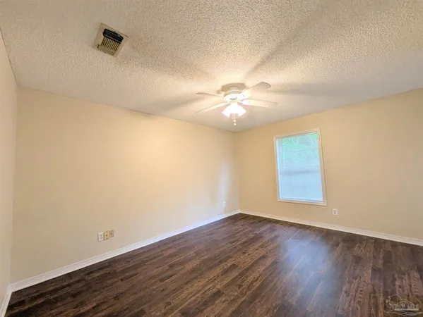 an empty room with wooden floor and chandelier fan
