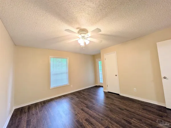 an empty room with wooden floor and chandelier fan
