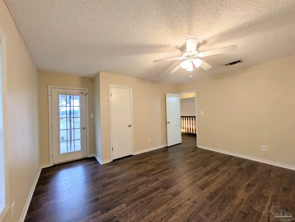a view of an empty room with window and wooden floor