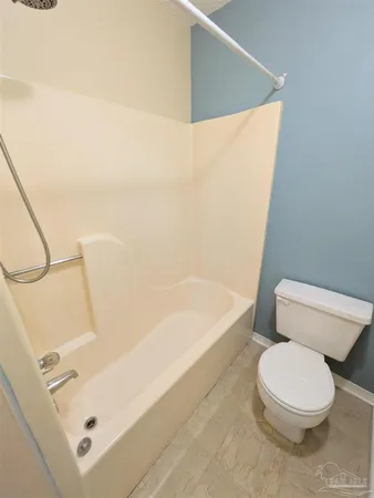 a white toilet sitting next to a bath tub and shower