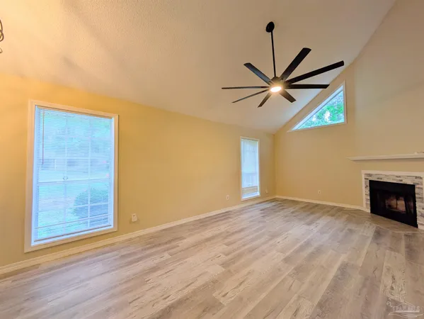 a view of an empty room with a window and a fireplace