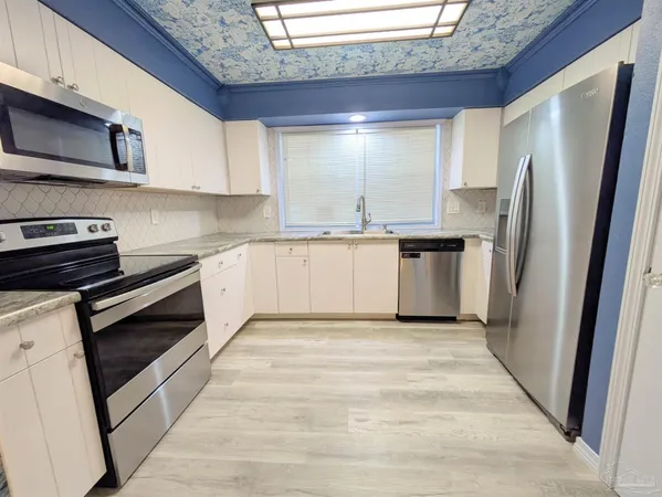 a kitchen with stainless steel appliances granite countertop a stove a refrigerator and a microwave