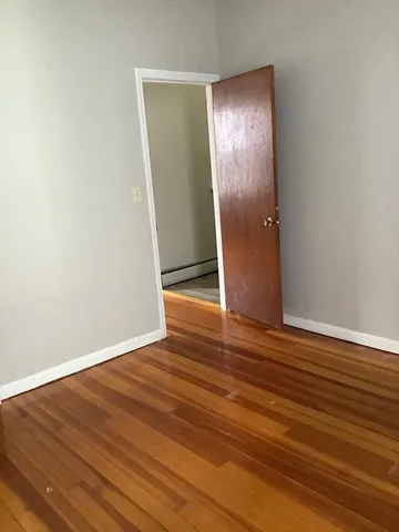 an empty room with wooden floor and entrance