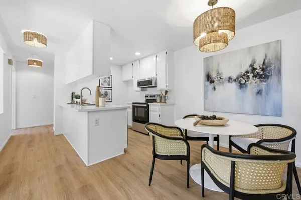 a kitchen with a dining table chairs and white cabinets