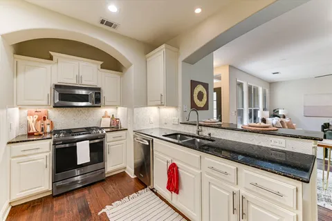 a kitchen with stainless steel appliances granite countertop a sink and a stove