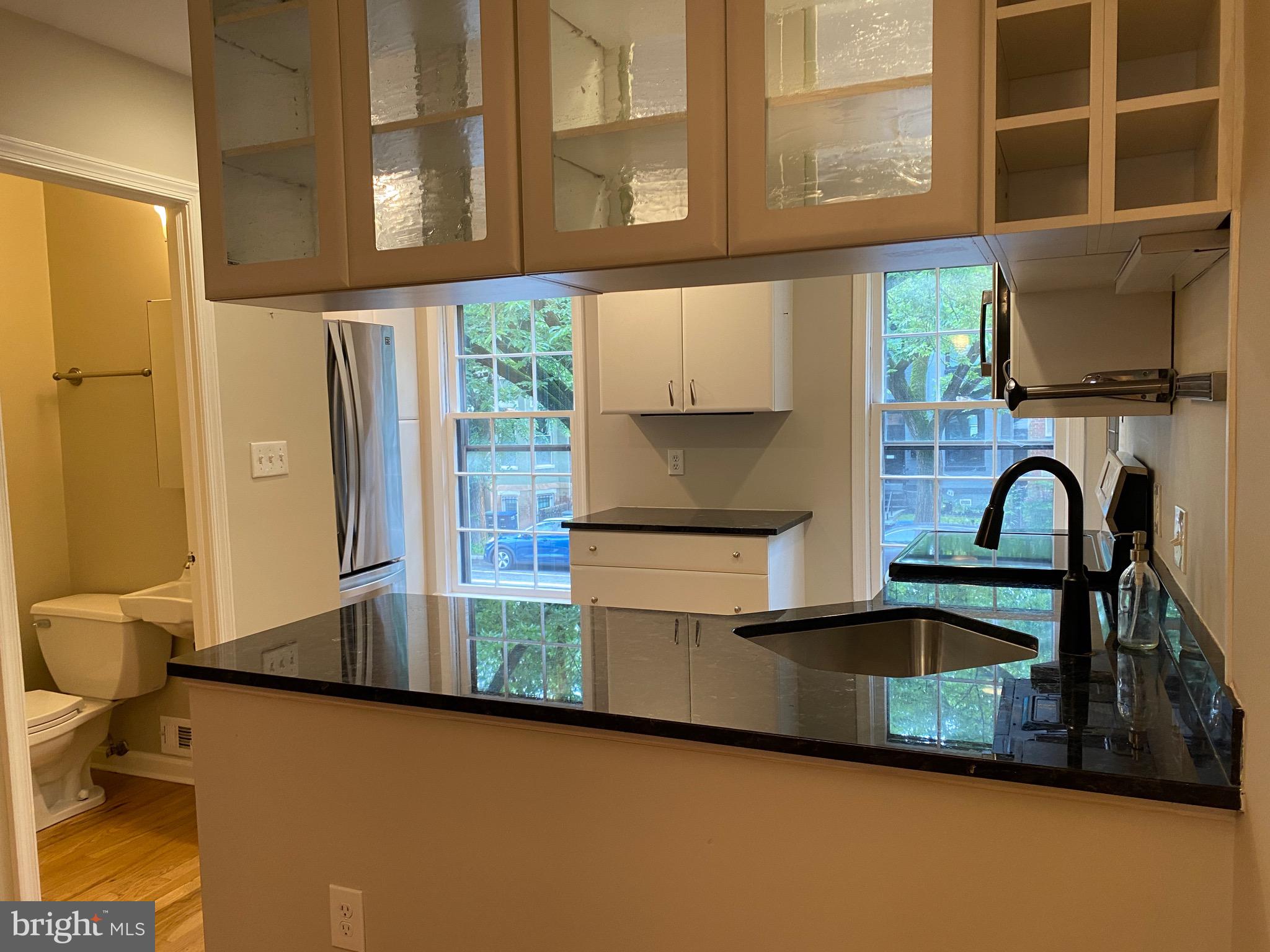 339 11th Street Southeast Washington, DC 20003 - Photo 22 of 39 a kitchen with stainless steel appliances granite countertop a refrigerator a stove and a sink with wooden floor