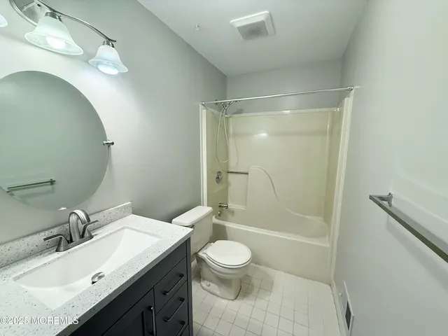 a bathroom with a granite countertop sink toilet a mirror and shower