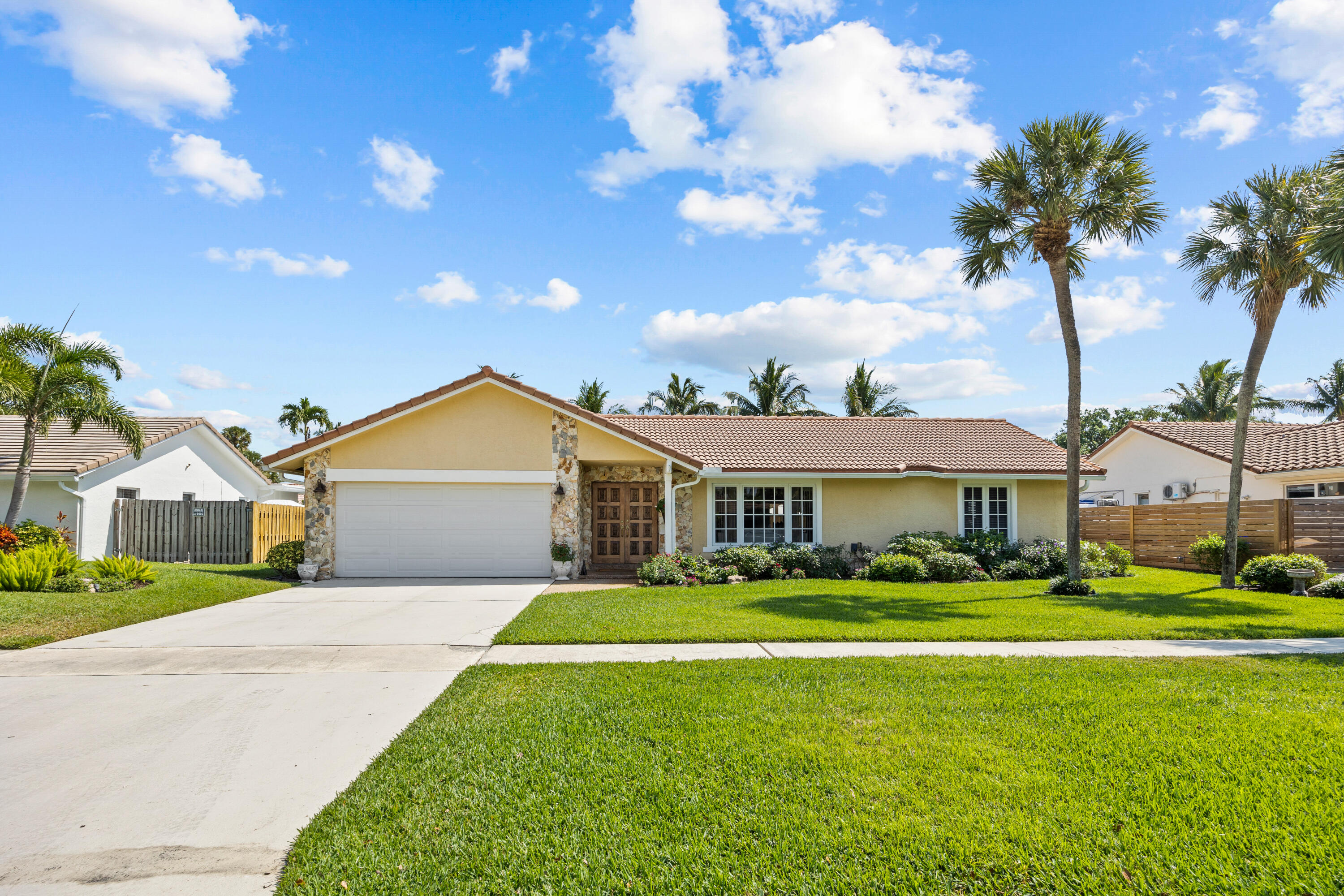 2136 Southwest 8th Avenue Boca Raton, FL 33486 - Photo 1 of 23 a front view of a house with a garden and trees