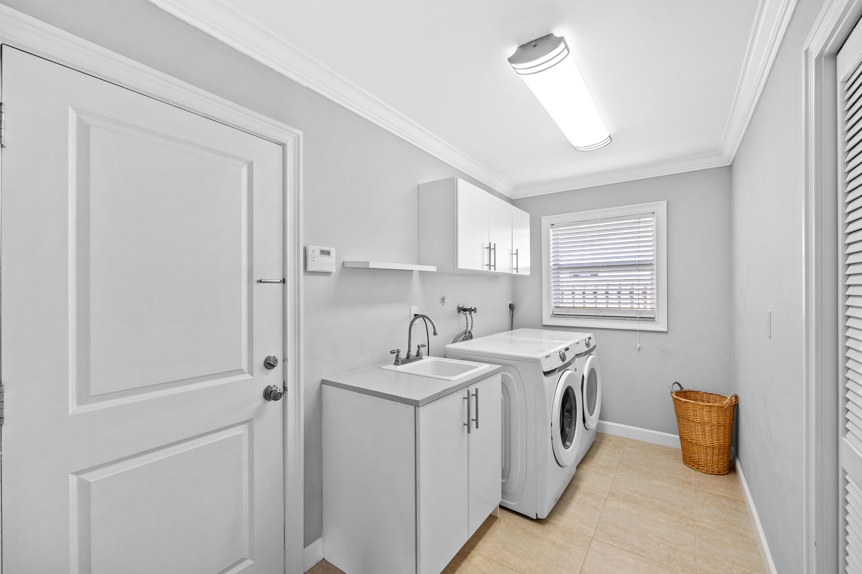 2136 Southwest 8th Avenue Boca Raton, FL 33486 - Photo 18 of 23 a utility room with cabinets washer and dryer