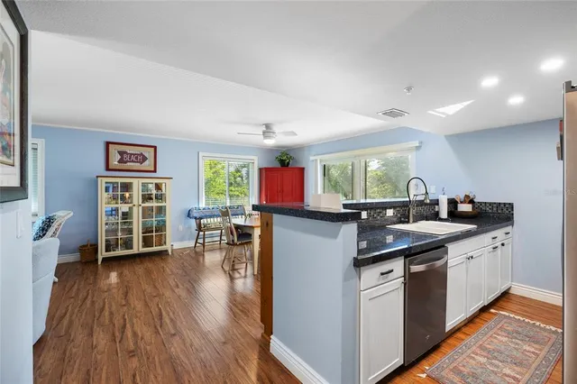 a kitchen that has a lot of cabinets a sink and appliances in it