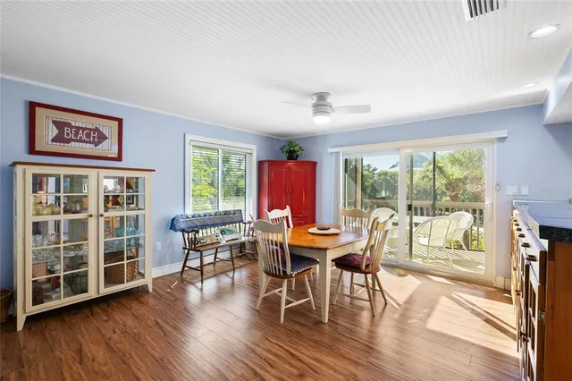 a dining room with wooden floor a glass table and chairs