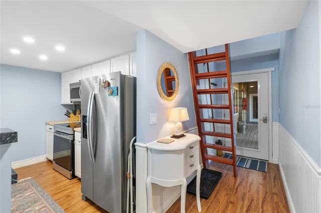 a view of a kitchen with fridge and workspace