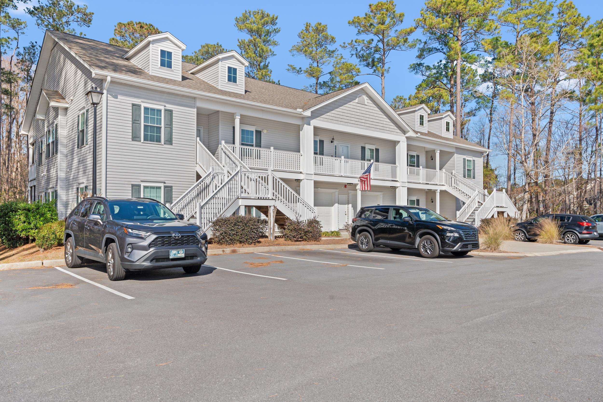 View of front of house featuring stairway, uncovered parking, roof with shingles, and covered porch