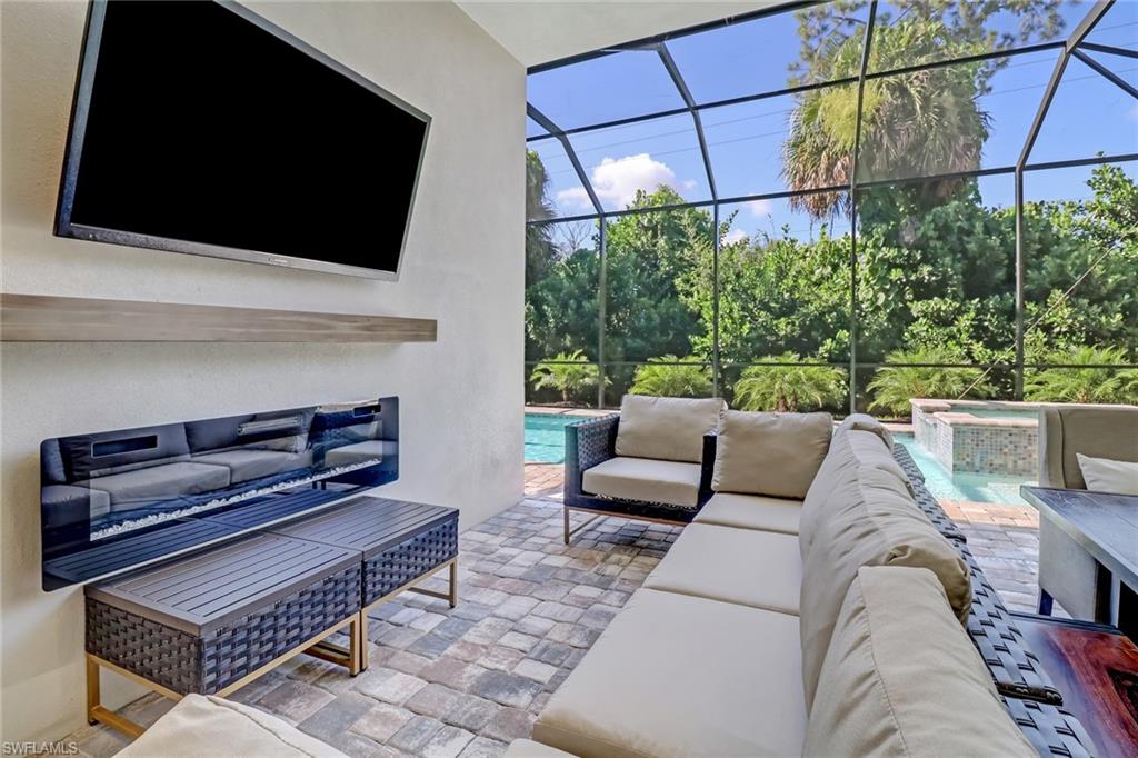 2875 Coco Lakes Drive Naples, FL 34105 - Photo 24 of 27 a living room with furniture a flat screen tv and a fireplace