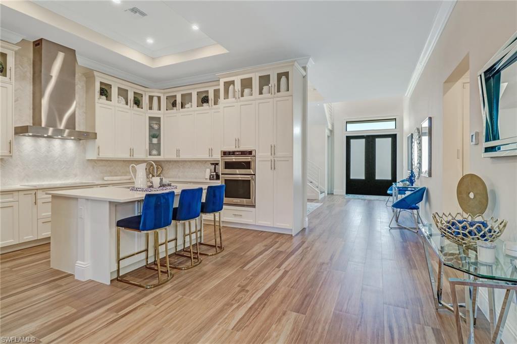 2875 Coco Lakes Drive Naples, FL 34105 - Photo 3 of 27 a open kitchen with stainless steel appliances granite countertop a stove a sink dishwasher and a stove with wooden floor