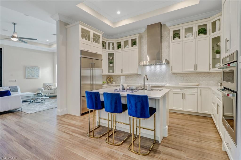 2875 Coco Lakes Drive Naples, FL 34105 - Photo 7 of 27 a kitchen with granite countertop a sink cabinets and wooden floor