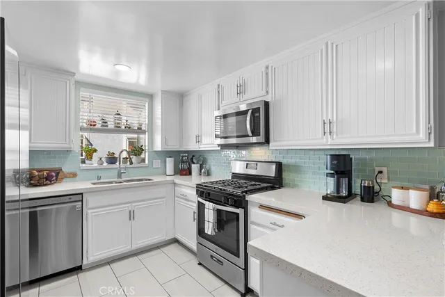 a kitchen with white cabinets stainless steel appliances and sink