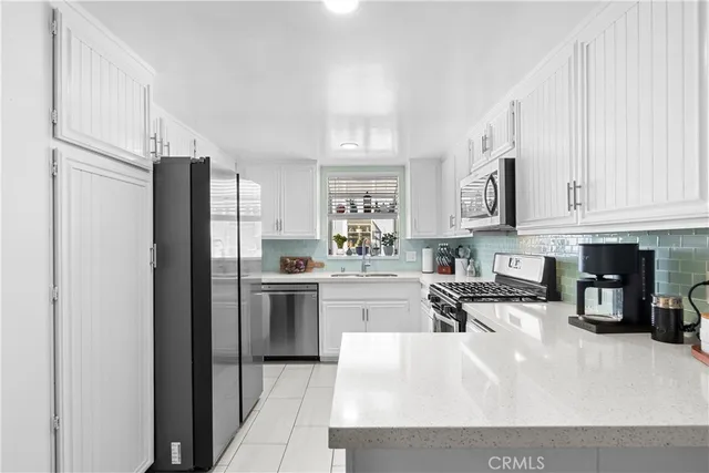 a kitchen with stainless steel appliances granite countertop a refrigerator sink and cabinets