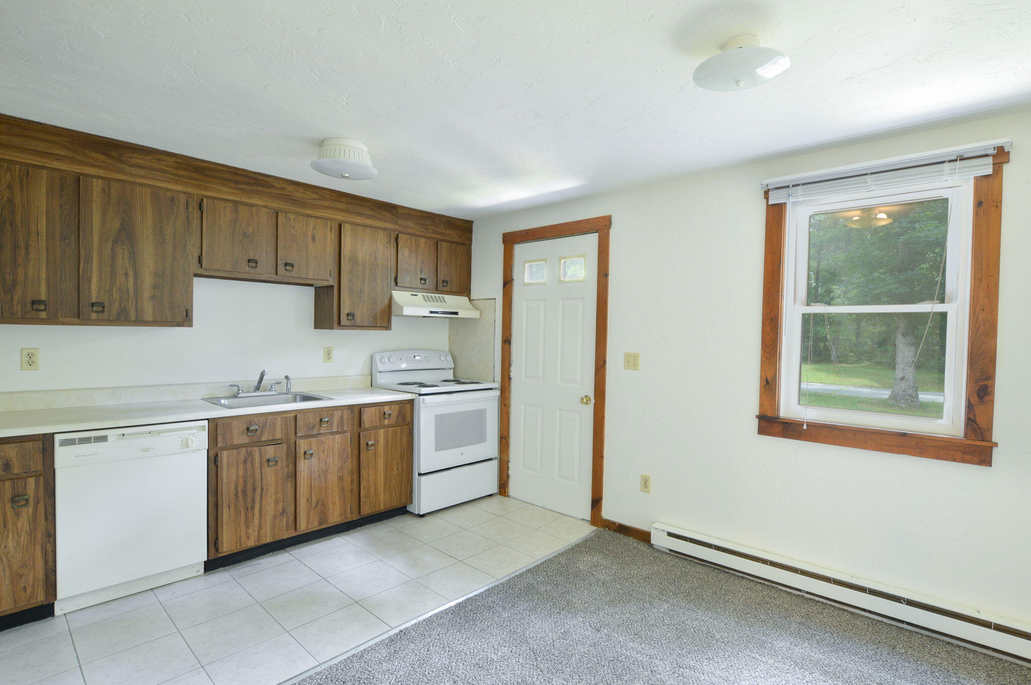 300 Falmouth Road, Unit 7D Mashpee, MA 02649 - Photo 8 of 18 a kitchen with granite countertop white cabinets and white stainless steel appliances