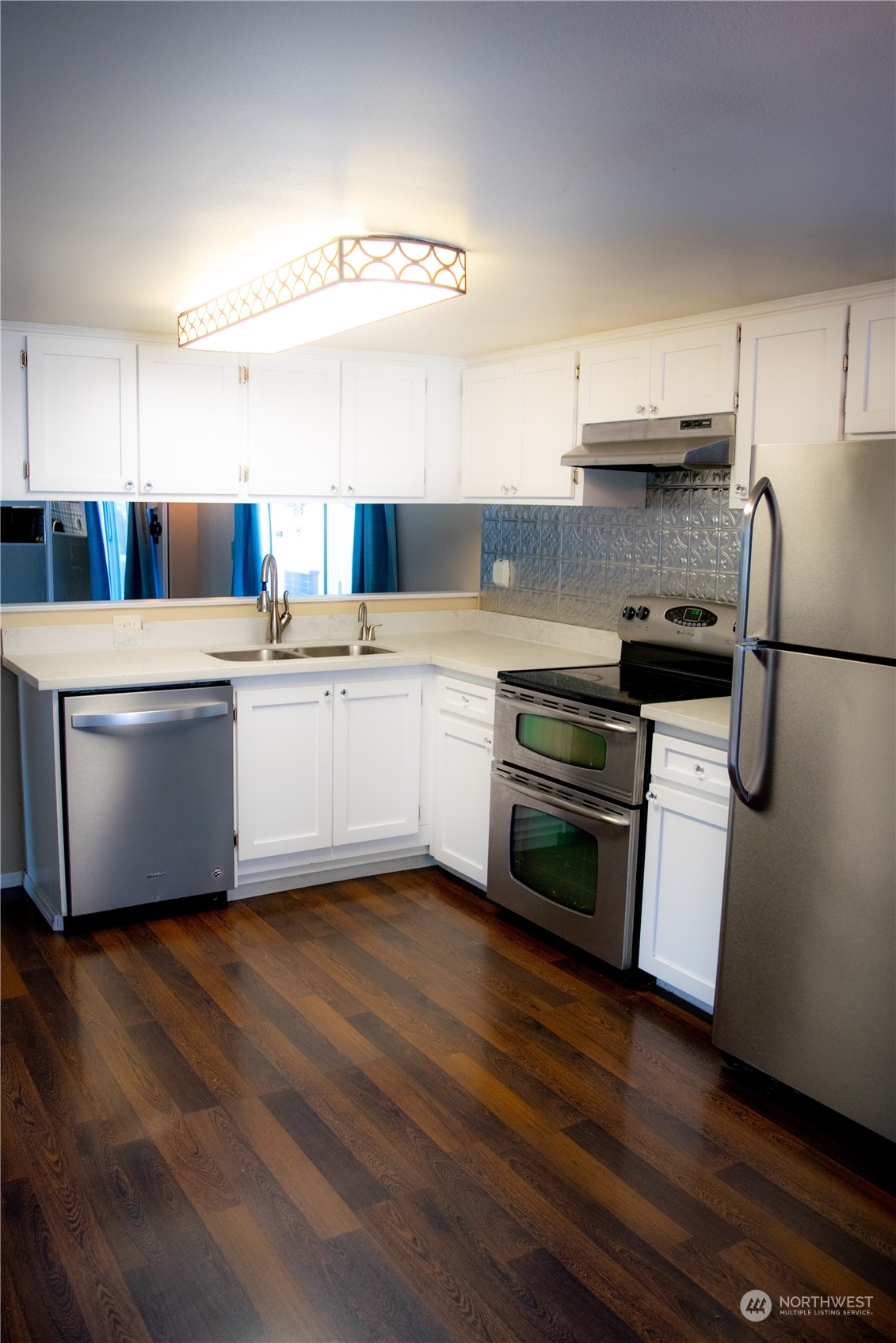 7701 Hardeson Road, Unit 2 Everett, WA 98203 - Photo 2 of 25 a kitchen with a white cabinets and white appliances