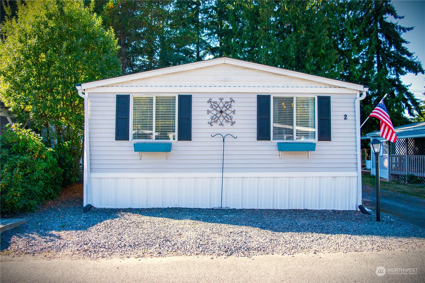 7701 Hardeson Road, Unit 2 Everett, WA 98203 - Photo 24 of 25 a view of a house with a small yard plants and large tree