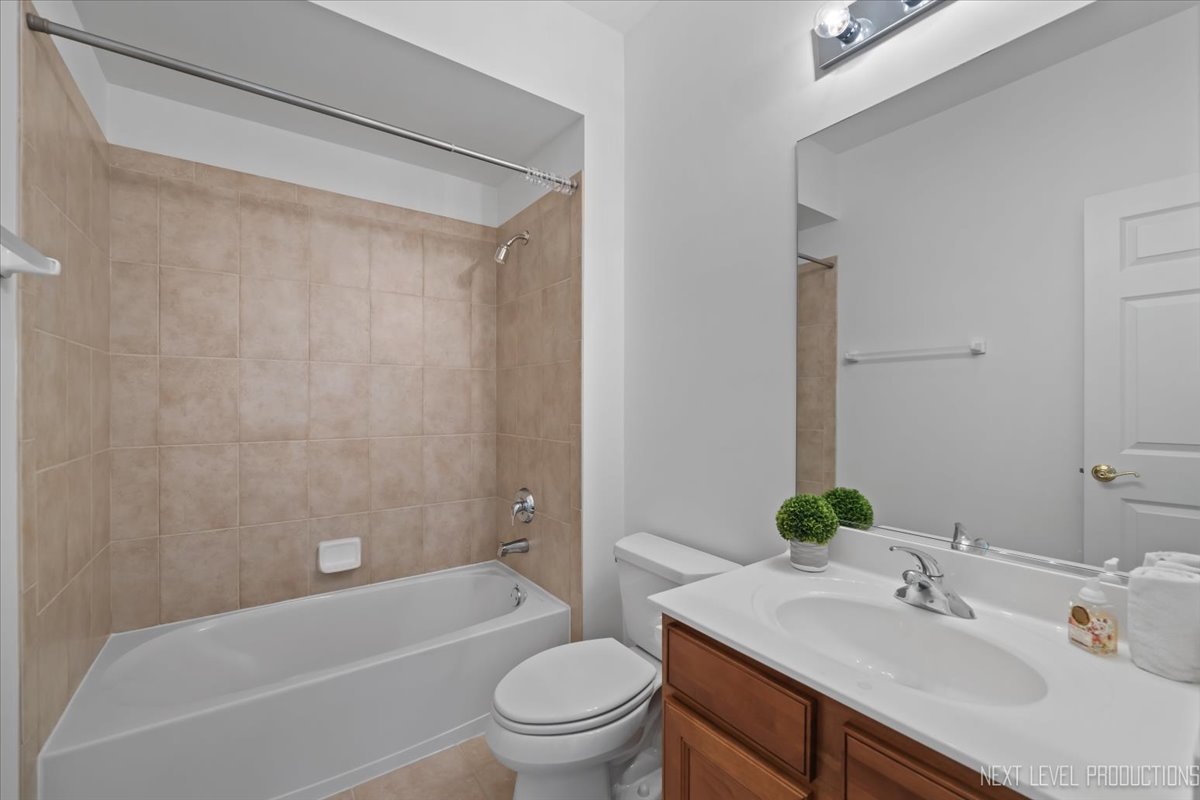 810 Cambridge Drive Batavia, IL 60510 - Photo 26 of 34 a bathroom with a sink a toilet a mirror a bathtub and shower