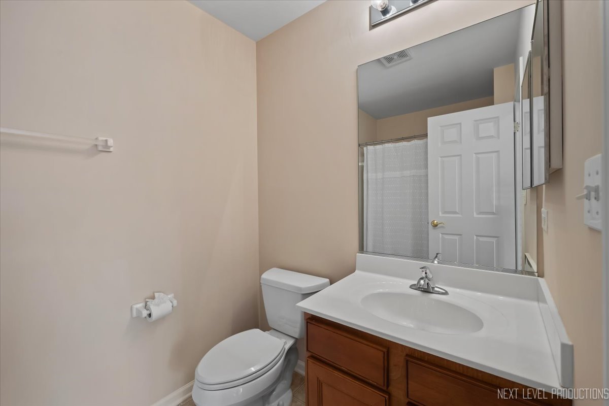 810 Cambridge Drive Batavia, IL 60510 - Photo 30 of 34 a bathroom with a toilet a sink a mirror and vanity