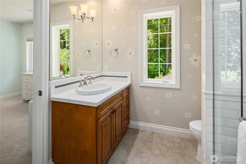 a bathroom with a sink a toilet and a window