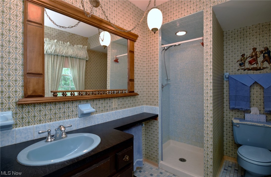 7912 Stow Road Hudson, OH 44236 - Photo 23 of 35 Bathroom featuring a tile shower, oversized vanity, mirror, and light tile floors