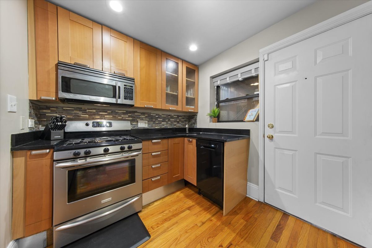 7423 North Sheridan Road, Unit 2W Chicago, IL 60626 - Photo 5 of 16 a kitchen with stainless steel appliances granite countertop a stove microwave and cabinets