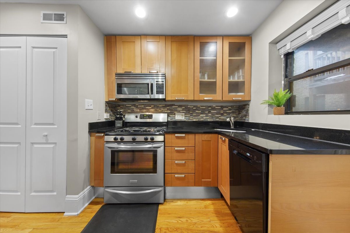 7423 North Sheridan Road, Unit 2W Chicago, IL 60626 - Photo 6 of 16 a kitchen with stainless steel appliances granite countertop a stove and a sink