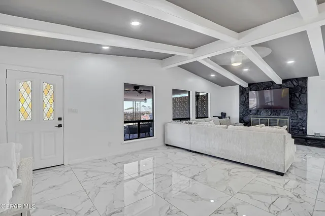 a living room with furniture and a view of kitchen