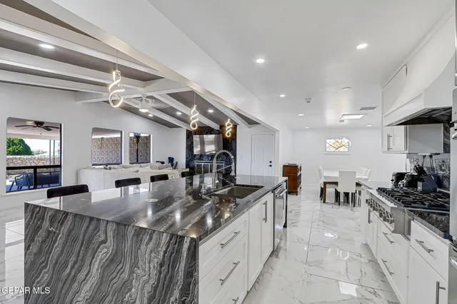 a kitchen with stainless steel appliances granite countertop a sink stove and cabinets