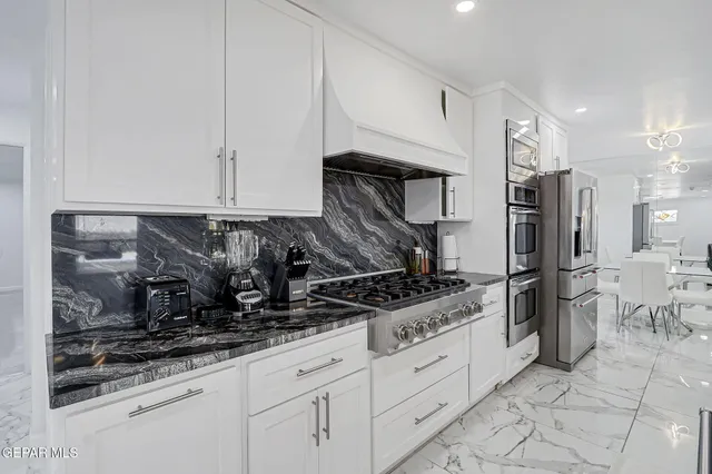 a kitchen with stainless steel appliances kitchen island granite countertop a sink and cabinets